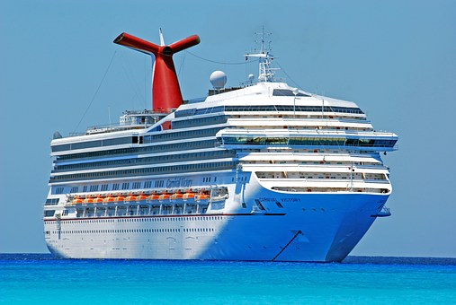 A photo of a cruise ship in the distance, on calm seas and a beautiful clear blue sky (cruise ships are ideal for lightweight mobility scooters.)