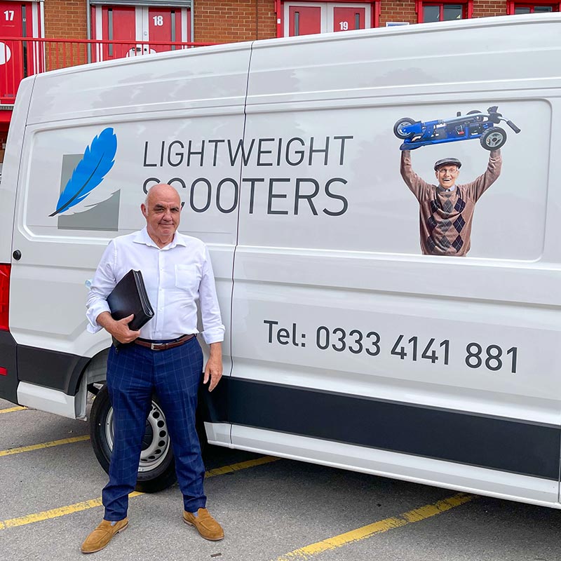 Tony standing beside a Lightweight Scooters van, ready for mobility scooter demonstrations.